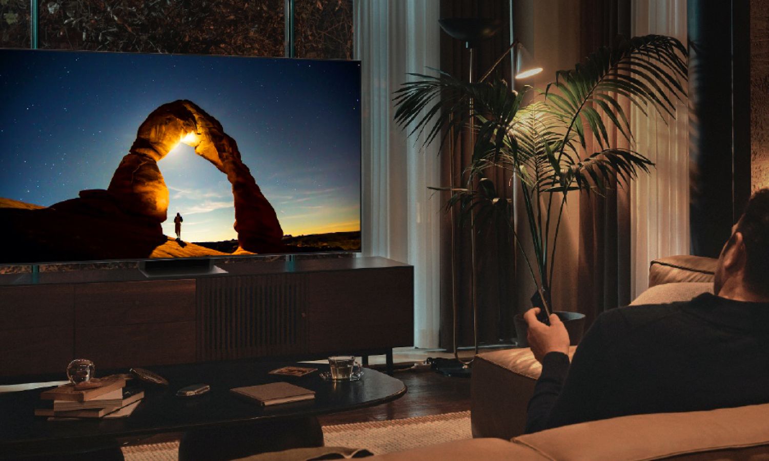 Man holding a remote watching a Samsung TV