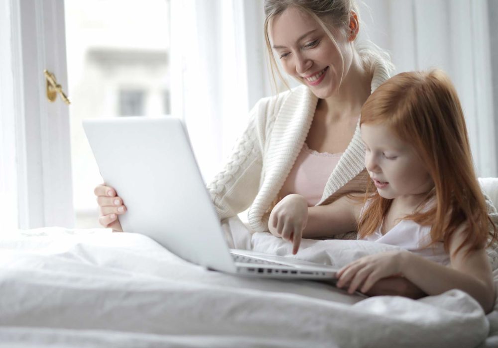 mom and daughter playing on laptop together